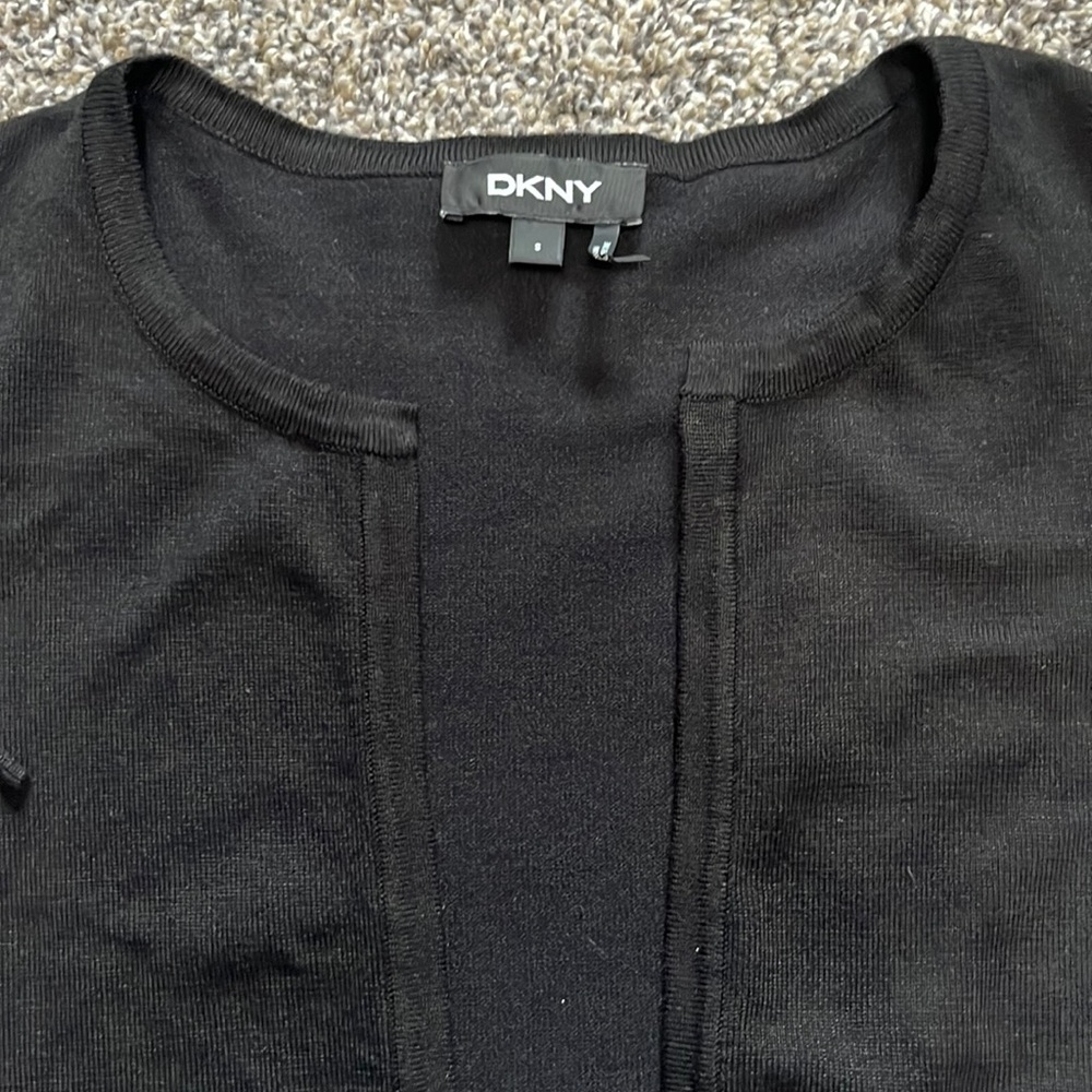 DKNY small black cropped cardigan sweater with black and white ruffle sleeves.